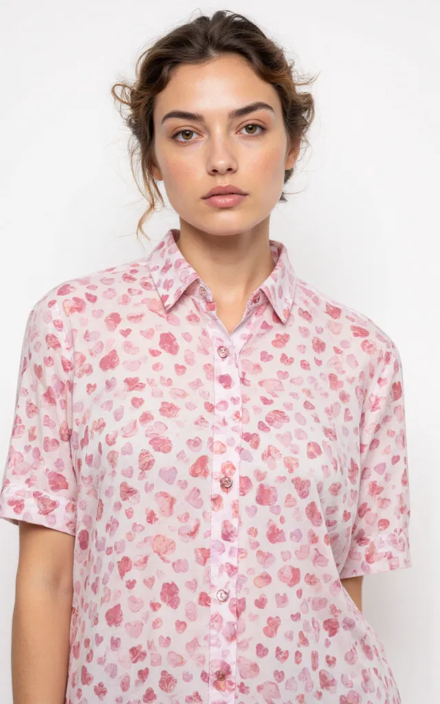 A French model wearing a Heart   shaped pattern   printed shirt, against a white background, in a front   facing bust portrait